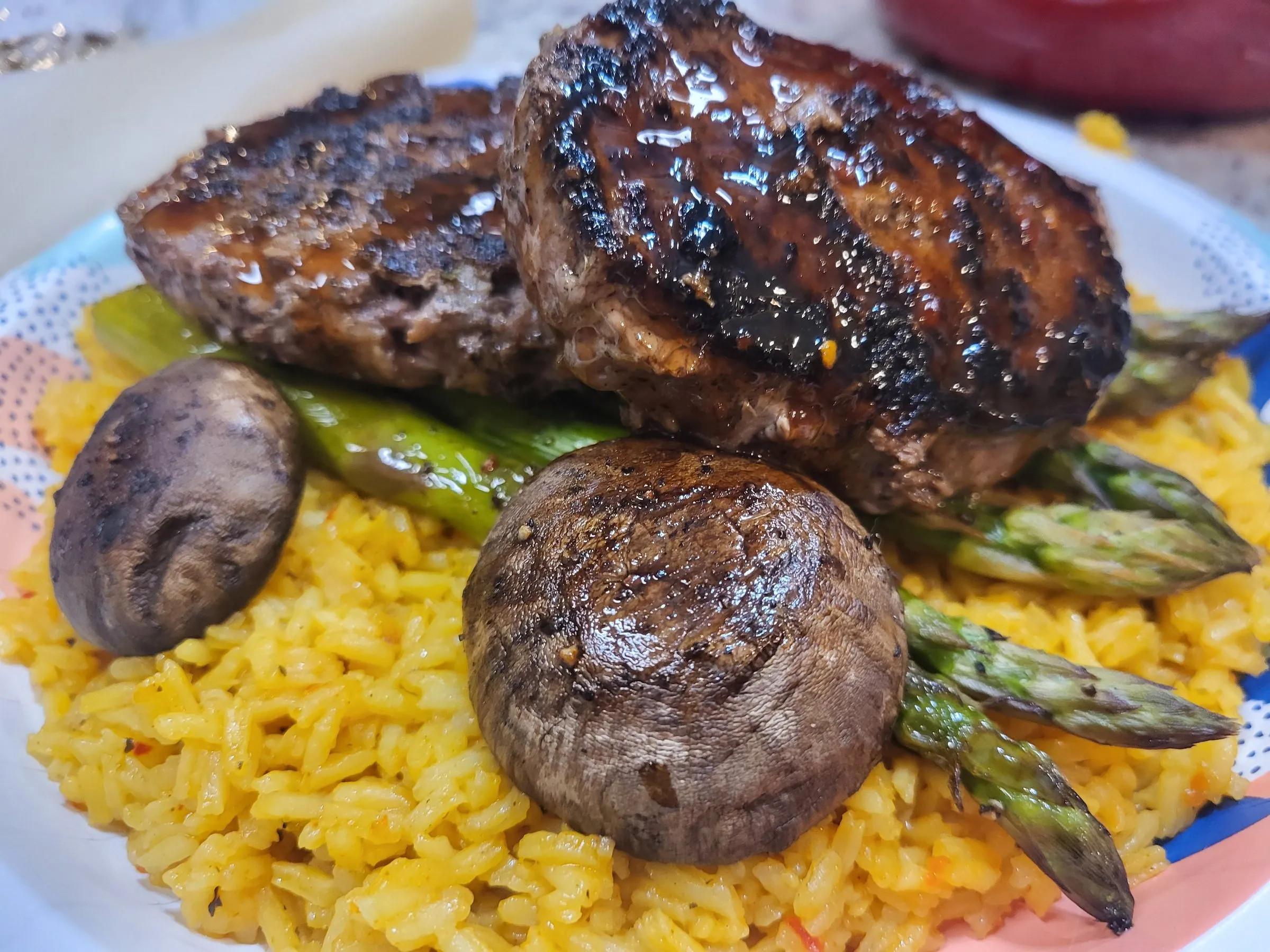 Glazed patties with asparagus and mushrooms over yellow rice