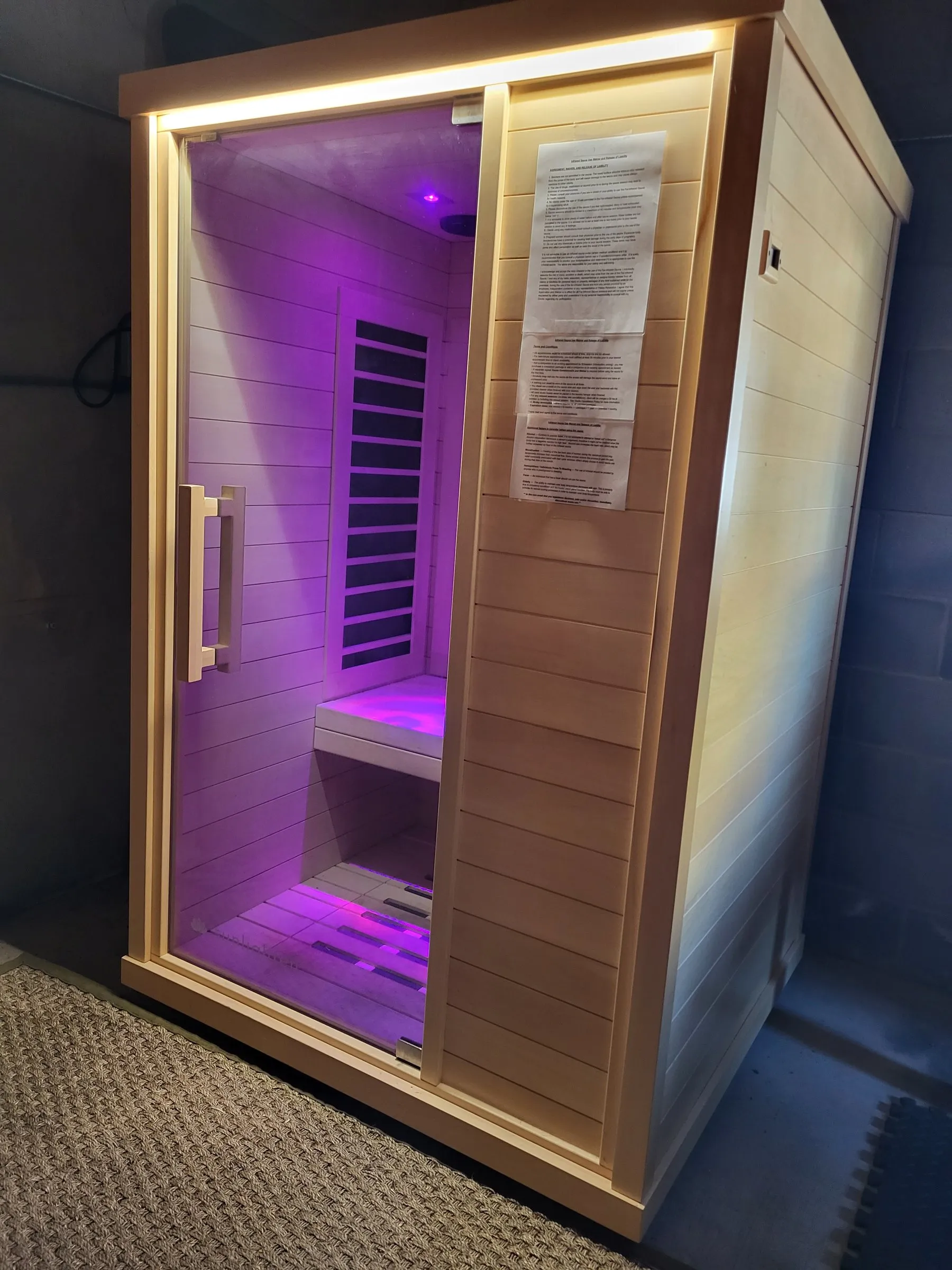 The infrared sauna glowing purple inside the Recovery Room