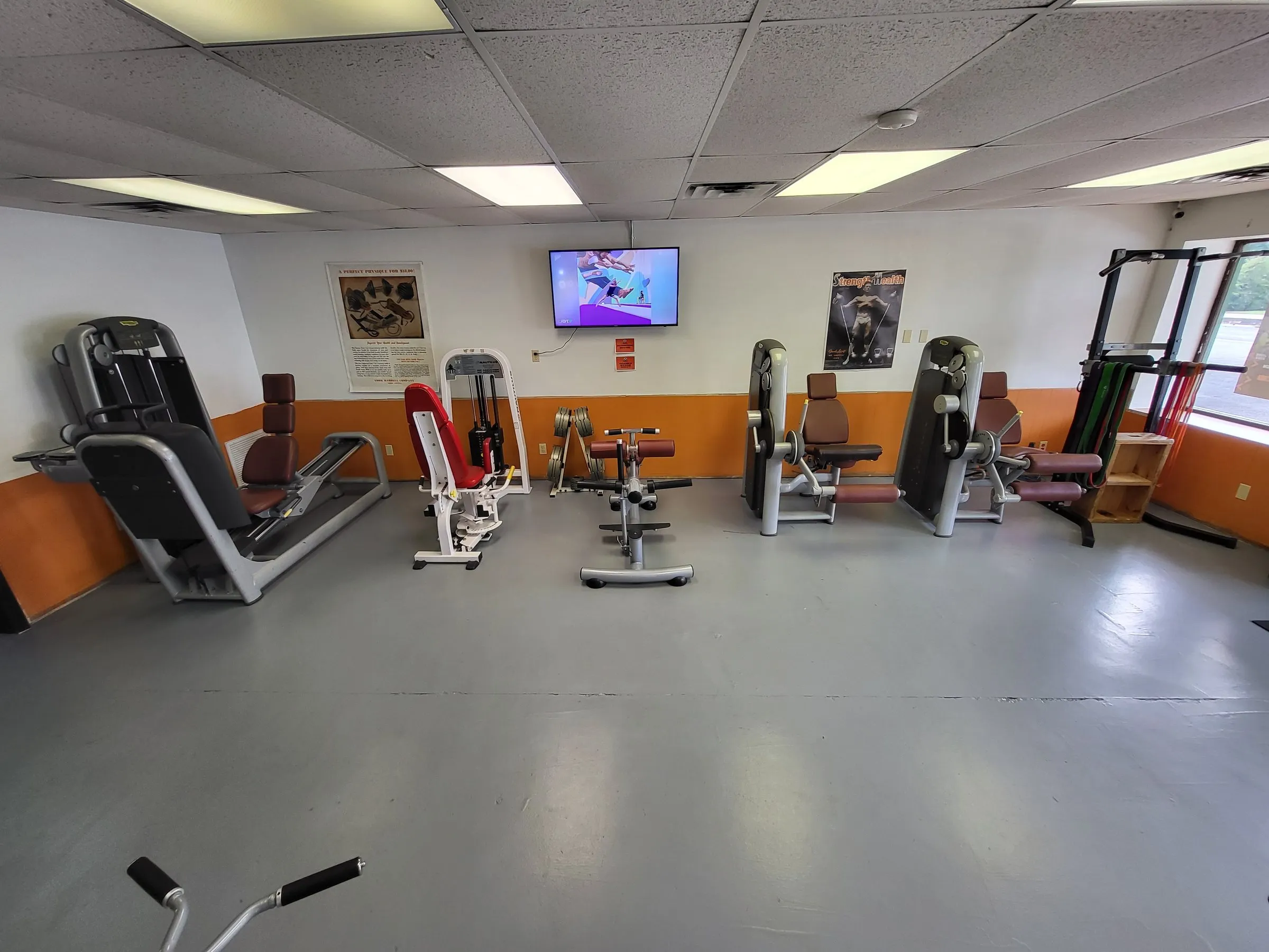 Strength machines including a leg press and chest press on the gym floor