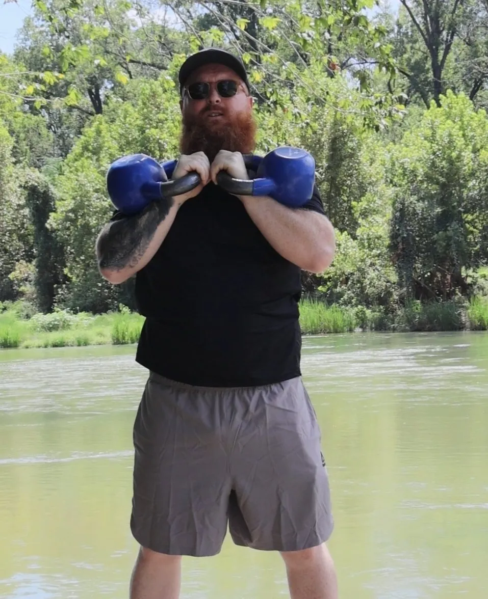 Uriah training with kettlebells outdoors by the river